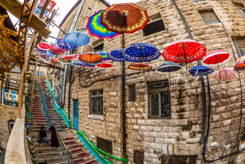 Umbrellas hanging above a narrow staircase in Amman, Jordan.